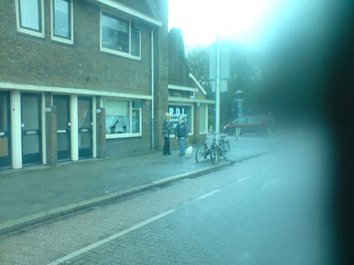 onduidelijke foto van 2 vrouwen pratend op de Amsterdamse Straatweg, vanuit de bus genomen